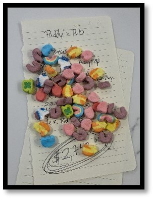 A large pile of colorful cereal marshmallows covering a handwritten financial note from Paddy's Pub.