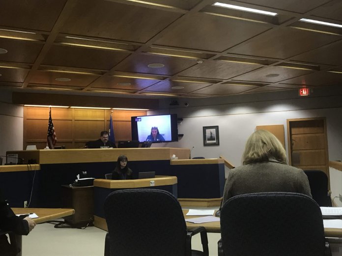 A courtroom scene with a notable focus on technology integration for remote proceedings