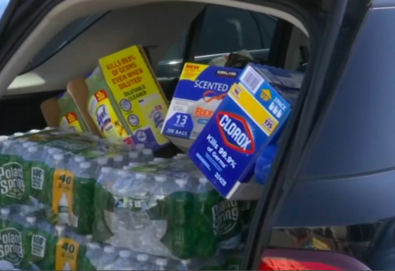 Car trunk loaded with bulk groceries and cleaning supplies after a shopping trip