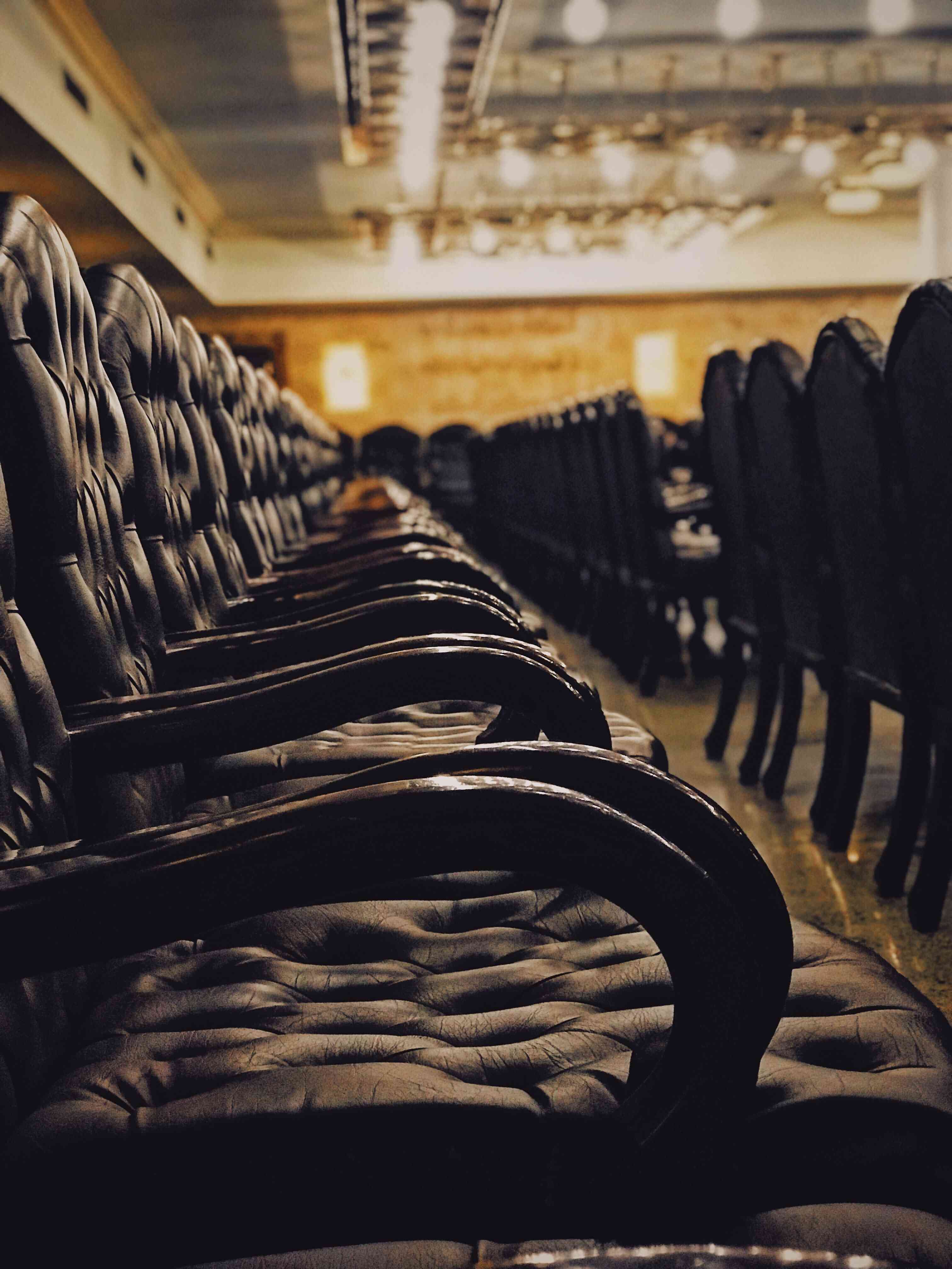 Rows of tufted leather chairs in a formal courtroom setting, emphasizing authority and judicial procedure