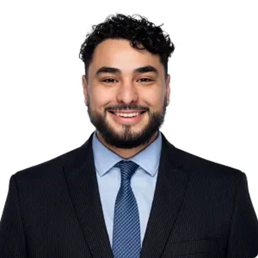 headshot photo of daniel torres paralegal smiling in black suit with blue shirt and dark blue tie